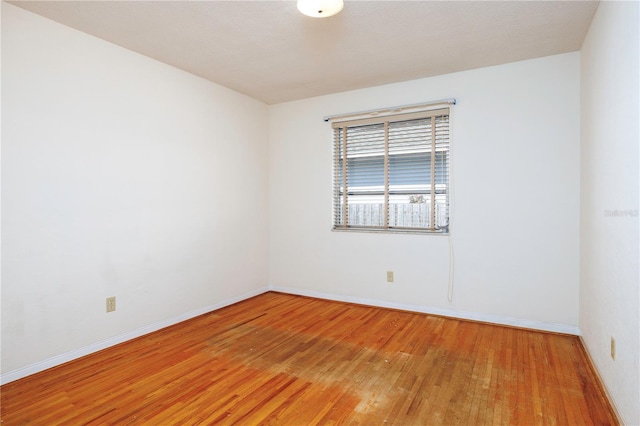 spare room featuring wood finished floors and baseboards