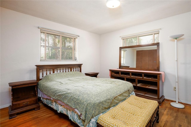 bedroom featuring baseboards and wood finished floors