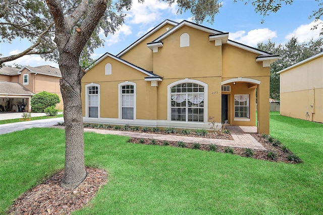 traditional home with a front yard and stucco siding