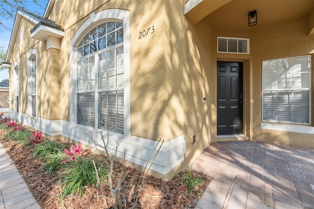 view of exterior entry featuring stucco siding