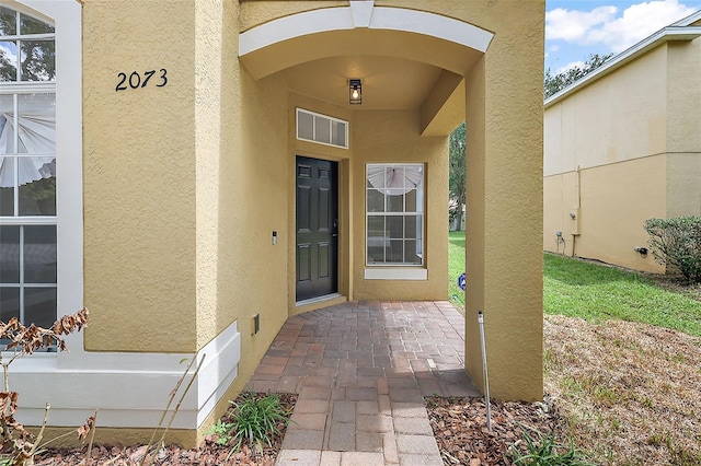 doorway to property featuring stucco siding