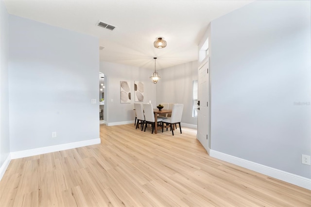 dining space featuring light wood-style flooring, visible vents, and baseboards