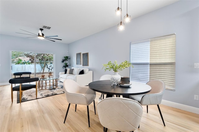 dining area with a ceiling fan, light wood-type flooring, visible vents, and baseboards