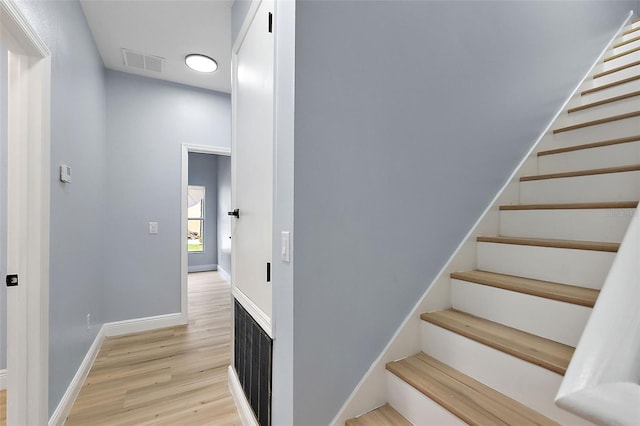 stairs featuring baseboards, visible vents, and wood finished floors