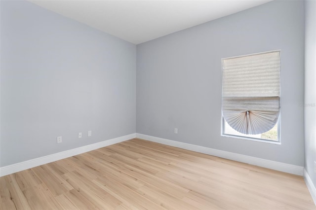 spare room featuring light wood-style flooring and baseboards