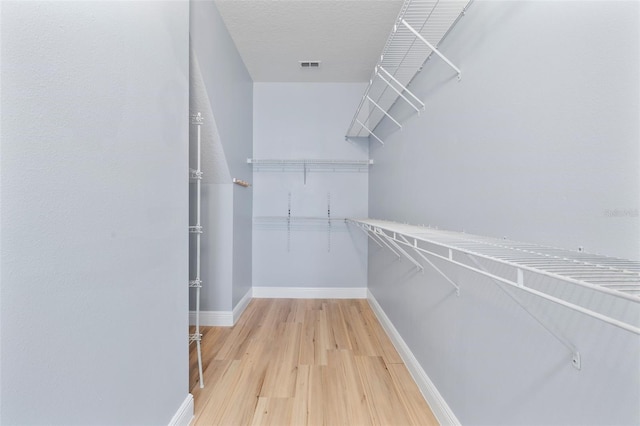 walk in closet featuring visible vents and wood finished floors