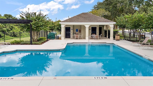 community pool with a patio and fence