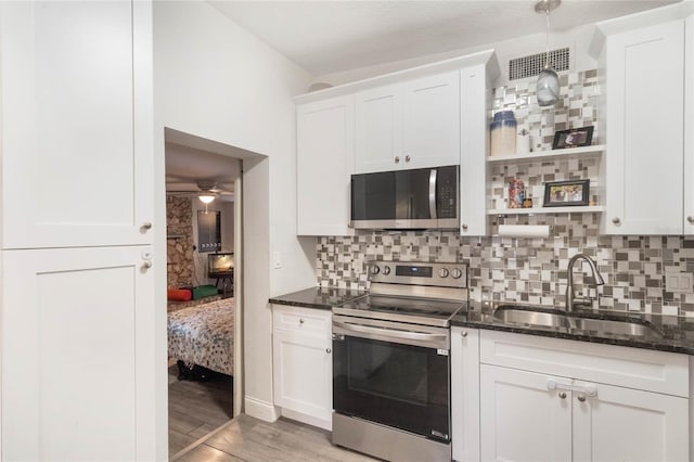 kitchen featuring white cabinets, light wood-type flooring, stainless steel appliances, and a sink