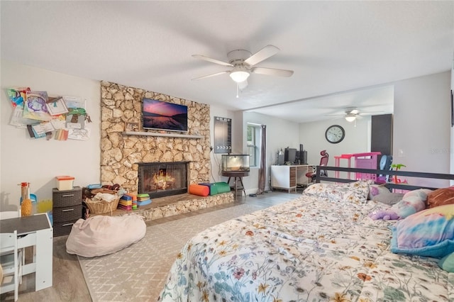 bedroom with a ceiling fan, a fireplace, and a textured ceiling