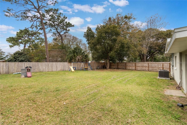 view of yard featuring a fenced backyard, central AC, and a playground