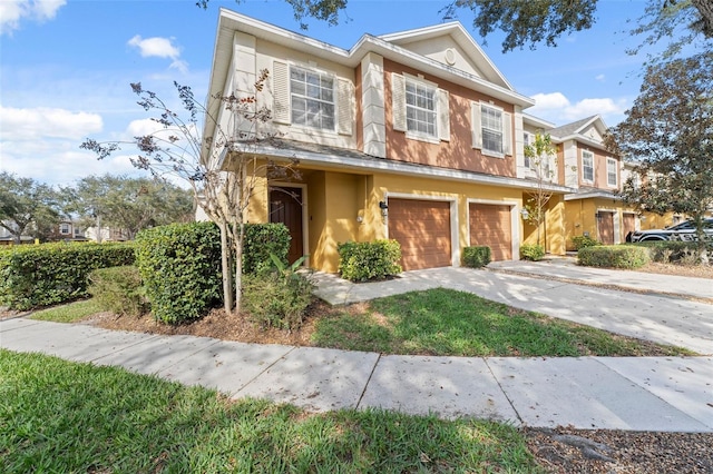 multi unit property featuring concrete driveway, an attached garage, and stucco siding