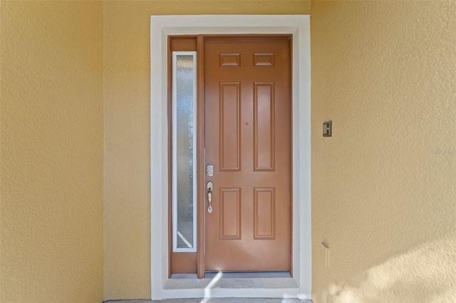 view of exterior entry with stucco siding