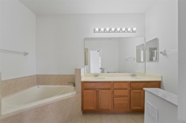 bathroom featuring a bath, tile patterned flooring, double vanity, and a sink