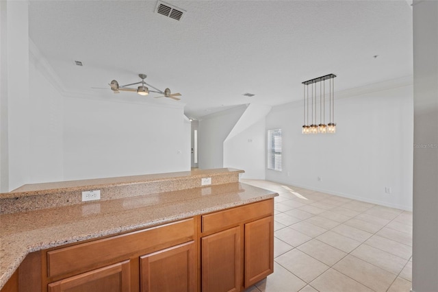 kitchen with light tile patterned floors, visible vents, light stone countertops, crown molding, and pendant lighting