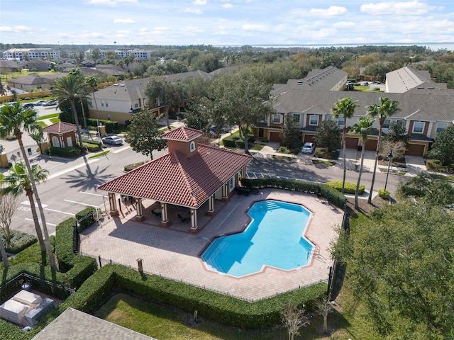 pool featuring a patio area, fence, and a residential view