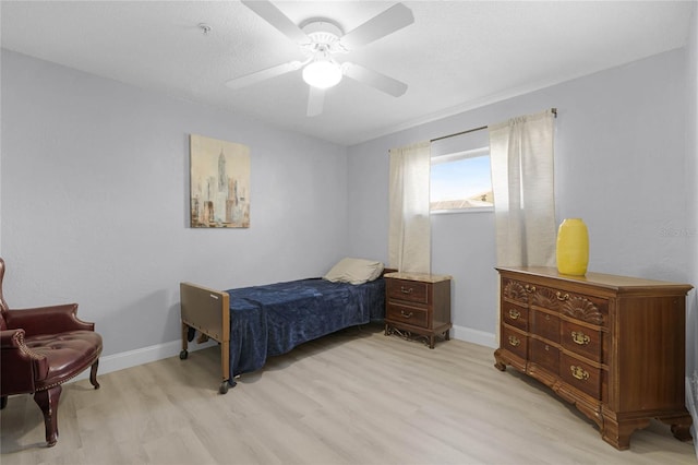 bedroom with baseboards, ceiling fan, and light wood-style floors