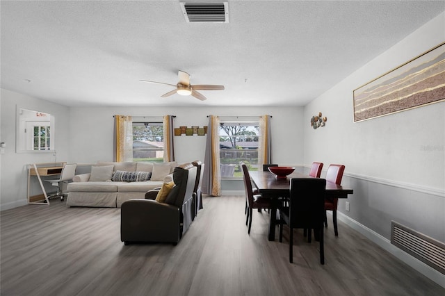 living room with a textured ceiling, visible vents, and dark wood-type flooring