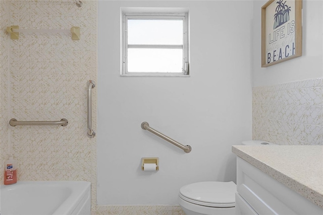 full bathroom featuring a tub, vanity, and toilet