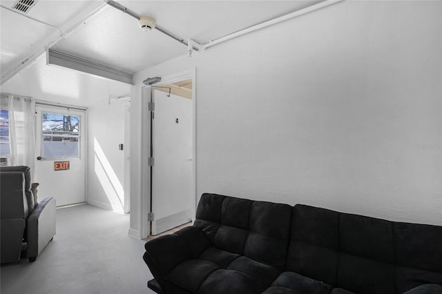 living area featuring visible vents and finished concrete flooring