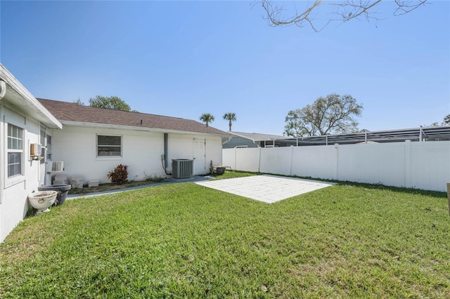 view of yard with a patio area, fence, and central AC unit