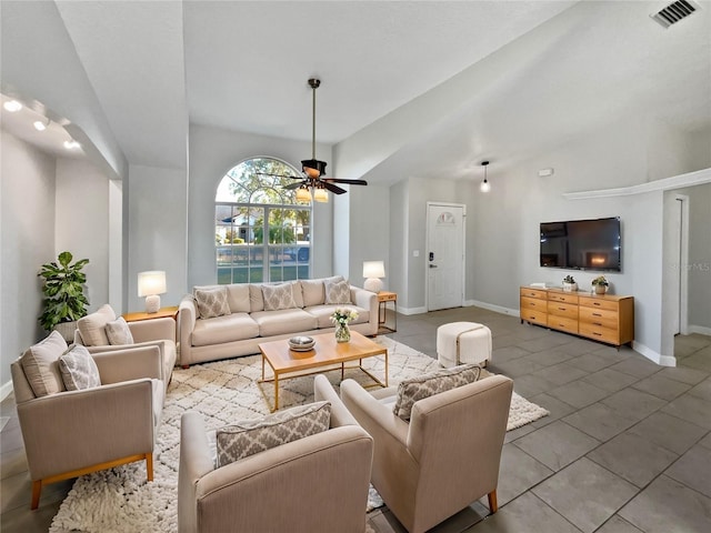 living area featuring lofted ceiling, a ceiling fan, visible vents, and baseboards