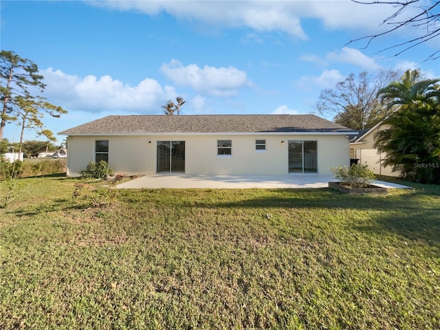 rear view of property with a yard, a patio, and stucco siding