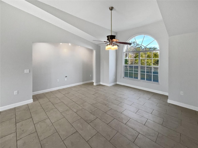 unfurnished dining area with ceiling fan, baseboards, and vaulted ceiling