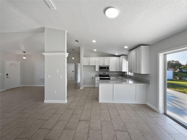 kitchen featuring appliances with stainless steel finishes, decorative light fixtures, a peninsula, white cabinetry, and a sink