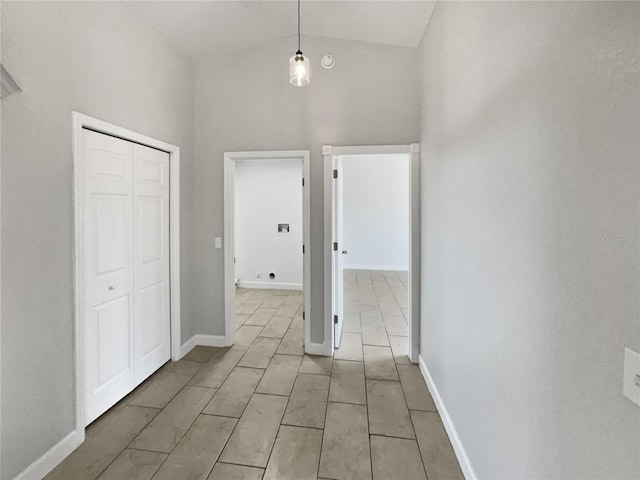 hall featuring vaulted ceiling and baseboards