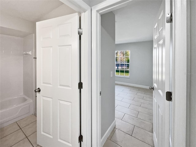 full bath featuring shower / washtub combination, tile patterned flooring, and baseboards