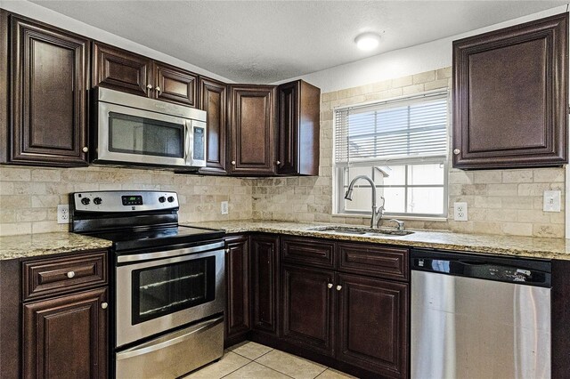 1622 Dolphin Dr, Saint Cloud, FL 34771 - kitchen with backsplash, stainless steel appliances, a sink, and light tile patterned flooring