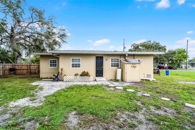 1622 Dolphin Dr, Saint Cloud, FL 34771 - rear view of property featuring a yard, fence, and stucco siding