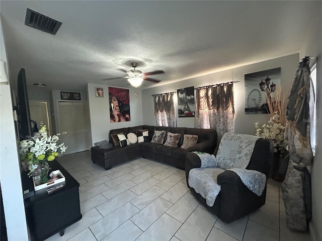 living area with ceiling fan, visible vents, and a textured ceiling