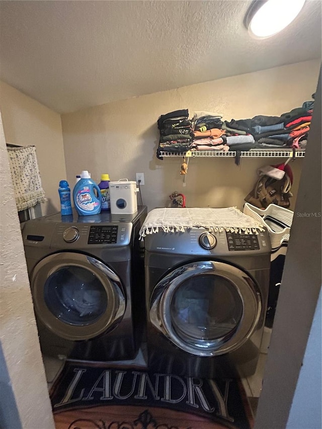 laundry area featuring laundry area, independent washer and dryer, and a textured ceiling