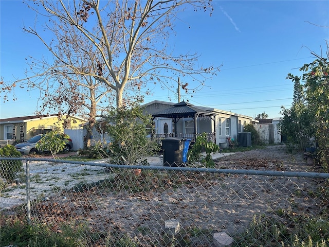 view of front of property with central AC unit, fence, and a gazebo