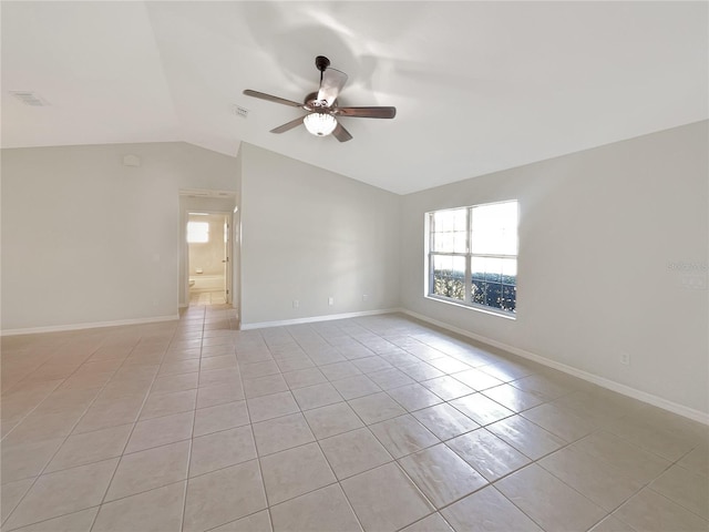 spare room with ceiling fan, vaulted ceiling, baseboards, and light tile patterned floors