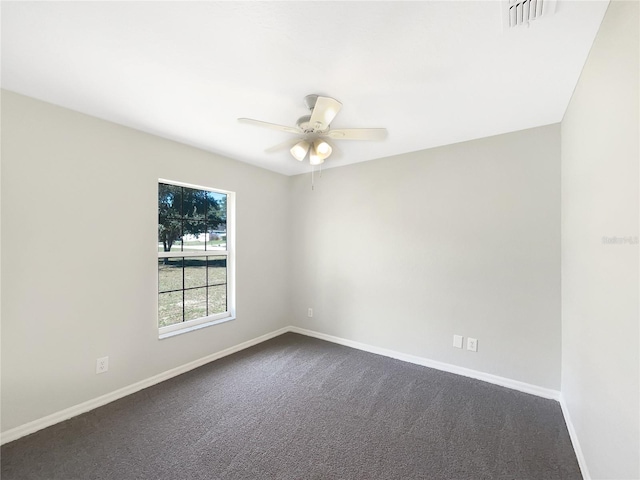 spare room with visible vents, dark carpet, baseboards, and ceiling fan