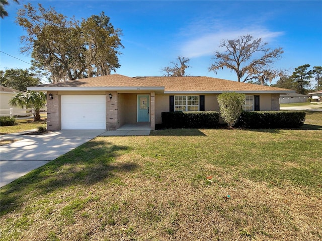 single story home featuring a front yard, brick siding, driveway, and an attached garage