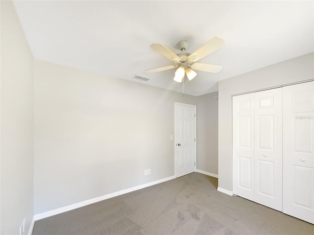 unfurnished bedroom featuring baseboards, visible vents, a ceiling fan, light colored carpet, and a closet