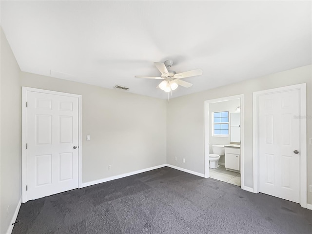 unfurnished bedroom with ceiling fan, connected bathroom, visible vents, baseboards, and carpet