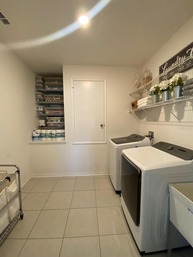 laundry room with light tile patterned floors, laundry area, a sink, visible vents, and washer and dryer