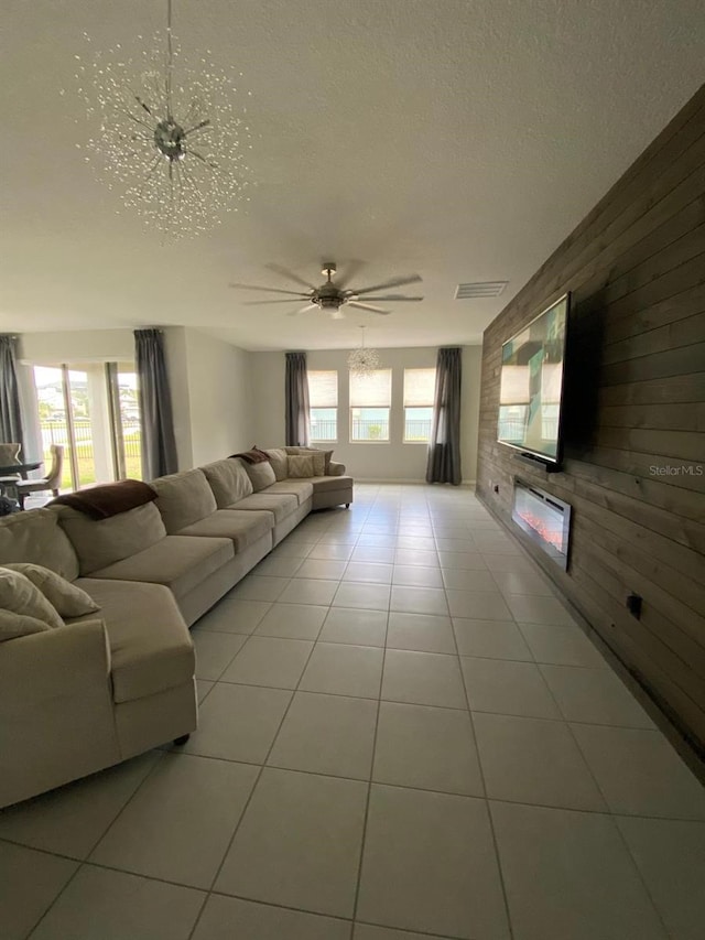 unfurnished living room featuring a healthy amount of sunlight, wooden walls, and a textured ceiling