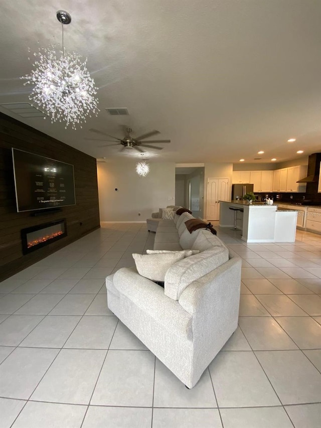 living area featuring a glass covered fireplace, visible vents, recessed lighting, and light tile patterned floors