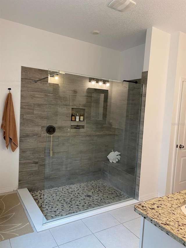 full bathroom featuring tile patterned flooring, visible vents, and a tile shower