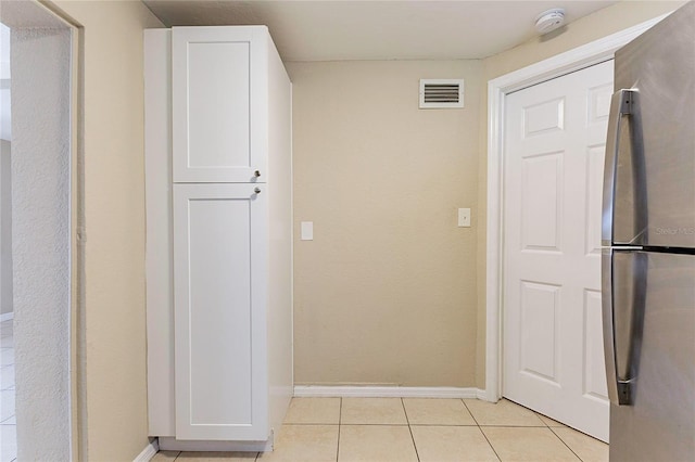 interior space featuring light tile patterned floors, baseboards, and visible vents