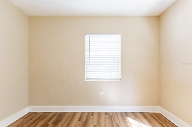 empty room with light wood-style flooring and baseboards