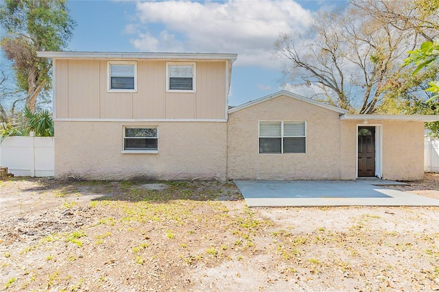 back of property featuring fence and a patio