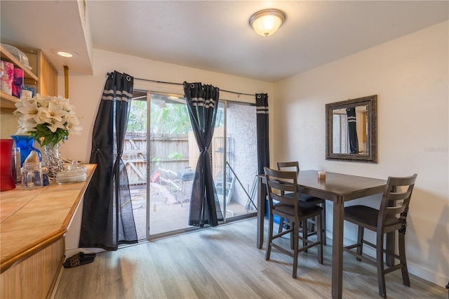 dining area with baseboards and light wood finished floors