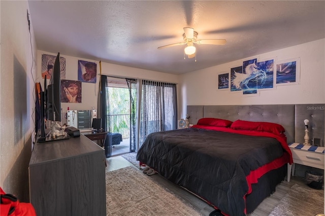 bedroom featuring access to outside, a textured ceiling, light wood-style flooring, and a ceiling fan