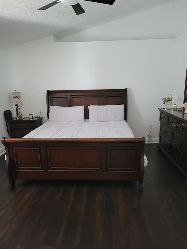 bedroom with a ceiling fan, a textured ceiling, dark wood finished floors, baseboards, and vaulted ceiling